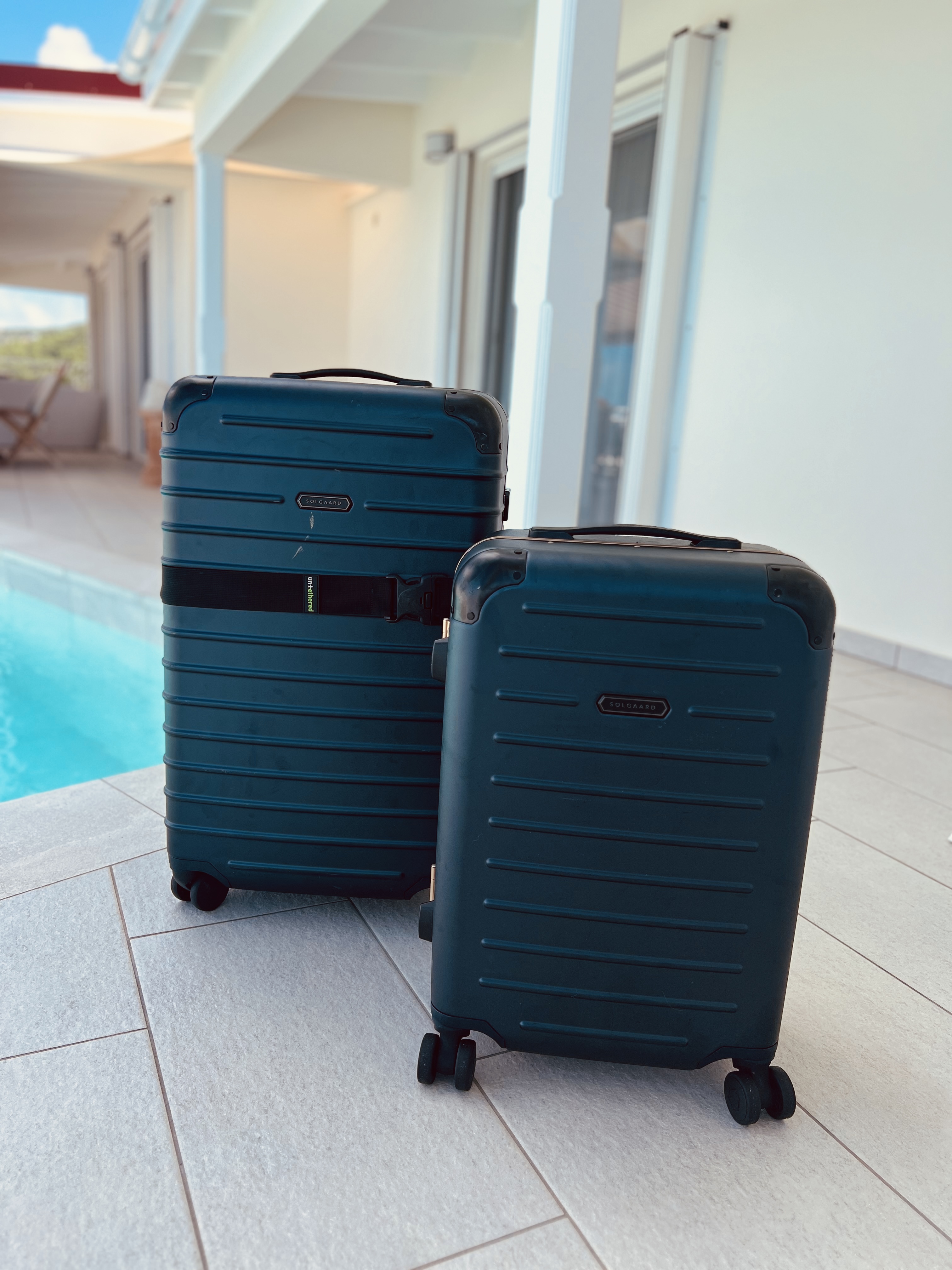 two luggage next to a pool